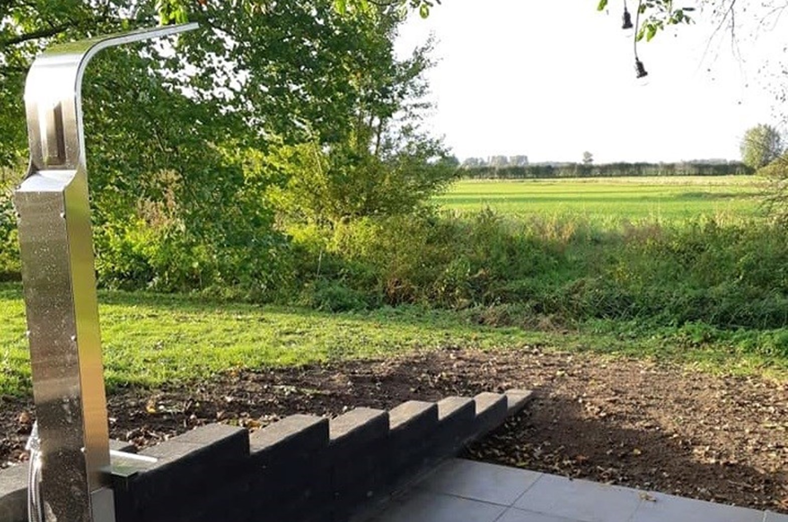 Buitendouche bij tiny house met uitzicht